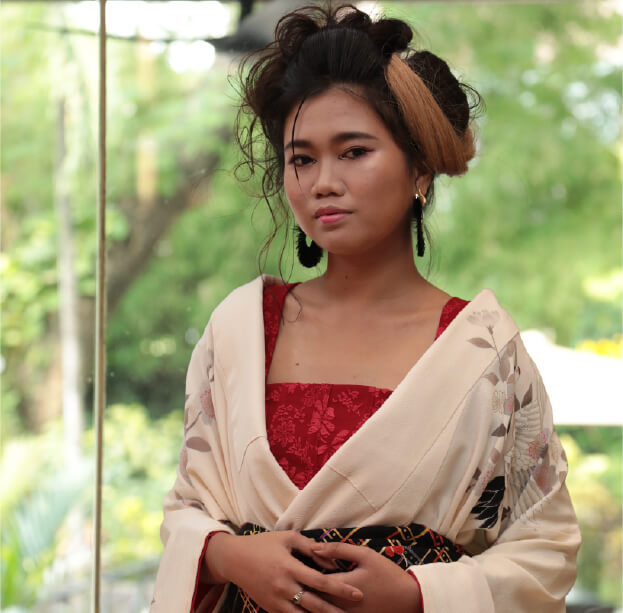 アイボリーの着物と赤の帯が印象的なモダン和装スタイル。ボリュームのあるアップヘアが華やかな印象。