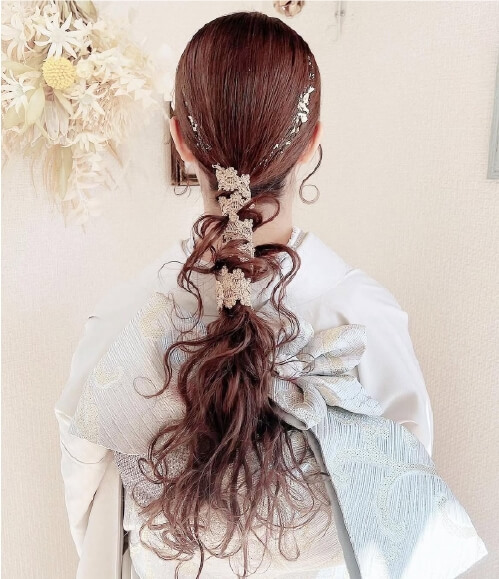 白い着物に合わせたロングポニーテールのヘアアレンジ。金の飾りがあしらわれた後ろ姿
